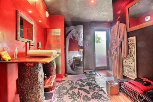 穆斯克龙古巴禅阿克提图德公寓的浴室设有红色的墙壁和水槽
