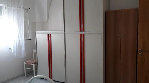 马鲁焦casa gialla mare del salento的窗边带红色条纹的白色冰箱