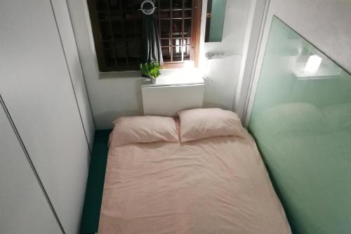 怡保EDM旅舍的一个小房间的小床,设有窗户