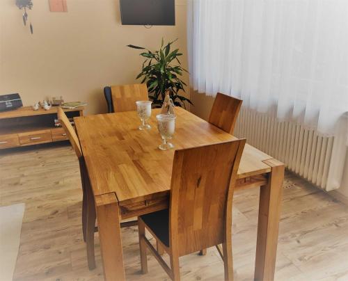 黑尔博尔茨海姆Ferienwohnung Rombachs Spatzennest的一张木餐桌,上面放着两杯玻璃杯