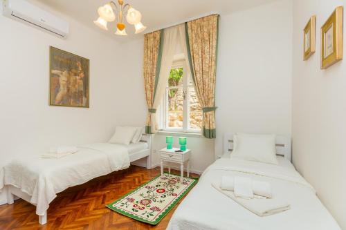 杜布罗夫尼克Apartment Villa Ahava的客房设有两张床和窗户。