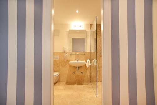 慕尼黑达斯慕尼黑酒店的一间带水槽、卫生间和镜子的浴室