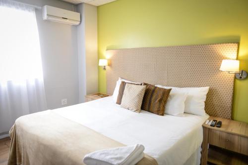 马塞卢Hokahanya Inn & Conference Centre的卧室配有一张带白色床单和枕头的大床。