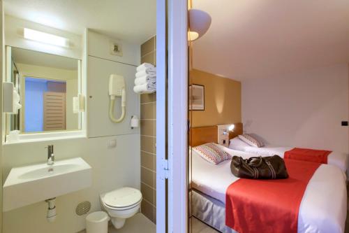 阿尔韦尔基里亚德里波尔圣艾米里昂酒店的浴室设有两张床、一个水槽和厕所