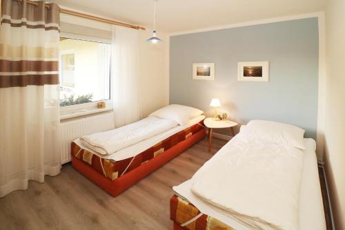 卡尔斯哈根Heydens Ferienhaus_HEYD的小型客房 - 带2张床和窗户