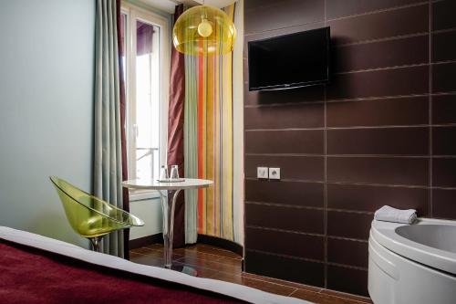 巴黎库尔赛乐之星酒店的一间带卫生间的浴室和墙上的电视