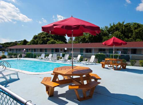 萨默斯波因特萨默斯波恩特伊克诺米汽车旅馆&套房酒店的游泳池旁带遮阳伞的野餐桌