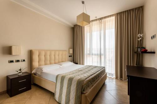 锡耶纳安吉赫尔酒店式公寓的一间卧室设有一张大床和一个大窗户