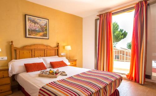 阿尔库迪亚港欧纳奥坎纳达公寓式酒店的一间卧室设有一张床和一个大窗户