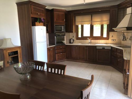 阿尔加卡Enastro Holiday Home的厨房配有木制橱柜和桌椅