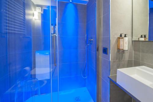 罗马Wellness Home Rome的蓝色的浴室设有淋浴和水槽
