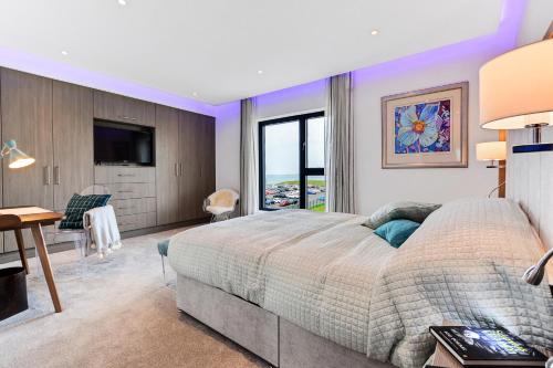 波特拉什Curran Gate Luxury Serviced Apartments, Portrush的一间卧室配有一张床、一张书桌和一台电视。