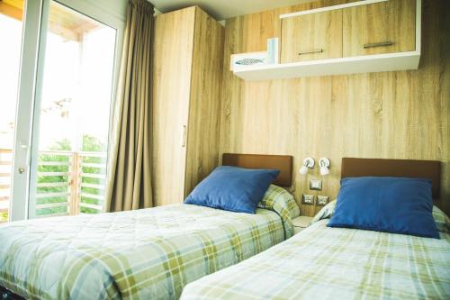 瓦莱克罗夏Camping Vallecrosia的卧室内两张并排的床