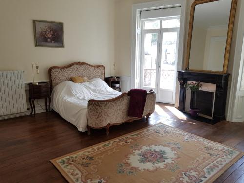 普隆比埃莱班Tradition Plombières的一间卧室配有一张床、一把椅子和地毯