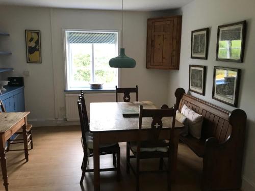 UleyOwlpen Manor Cottages的一间带桌椅和窗户的用餐室