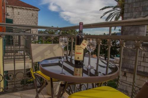 赫尔采格诺维Apartmani Skver Sanja的阳台上的桌子和两杯葡萄酒