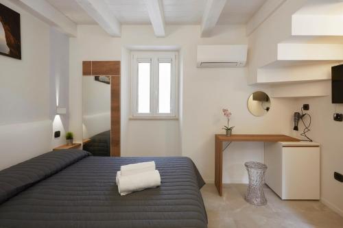 锡罗洛Affittacamere Somnium的一间卧室配有一张床、一张书桌和一个窗户。