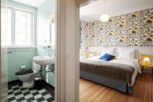 霍恩拜克斯特朗别墅的一间卧室配有一张床,浴室设有水槽