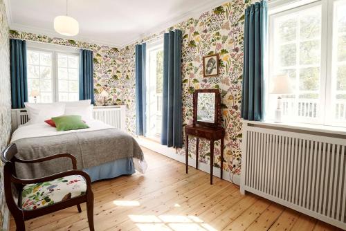 霍恩拜克斯特朗别墅的一间卧室配有一张床和花卉壁纸