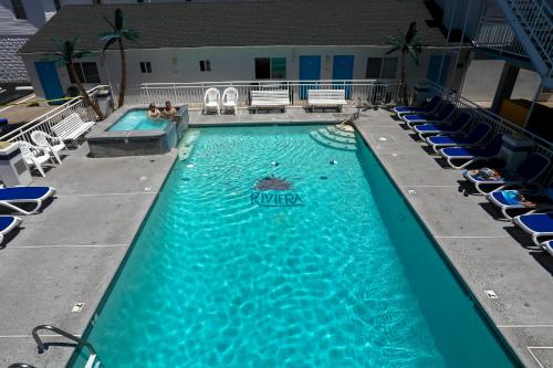 怀尔德伍德里维埃拉套房汽车旅馆的一座带椅子和人手的大型游泳池