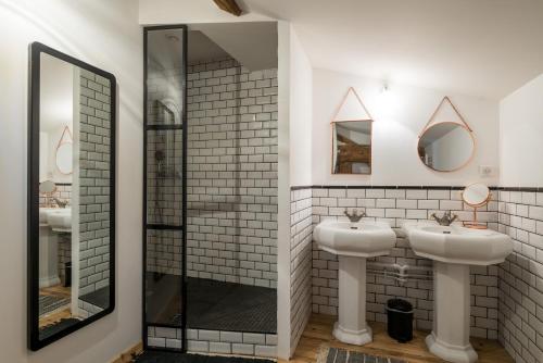 LanciéGite le Pot de Vin的浴室设有2个水槽和2面镜子