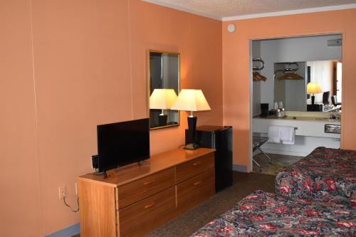 尤里卡斯普林斯Thurman's Lodge的酒店客房,配有床铺和梳妆台上的电视