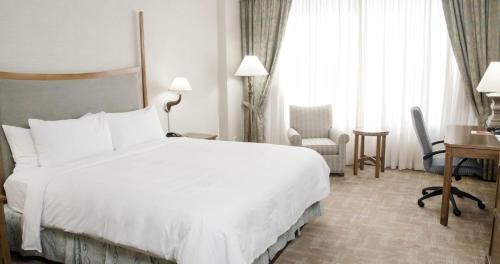 埃德蒙顿克里河赌场度假村的酒店客房设有一张白色大床和一张书桌