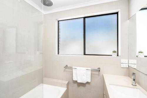 拜伦湾Byron Bay Accom - Balcony on Lawson的白色的浴室设有水槽和窗户。