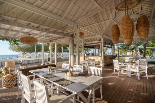 吉利特拉旺安吉利埃科别墅酒店的一个带桌椅的户外用餐区和海滩