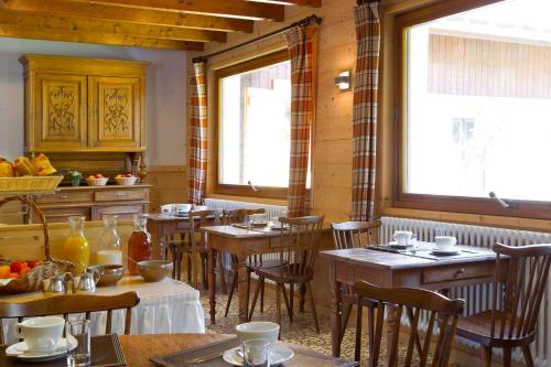 圣让德锡克斯特贝塞特之家酒店的餐厅设有木桌、椅子和窗户。