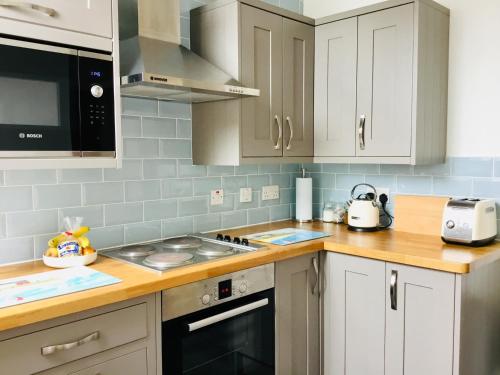 波马利斯Mount Pleasant Apartments的厨房配有白色橱柜和炉灶烤箱。