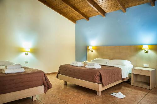 拉瑟拉西酒店的一间卧室设有两张床和蓝色的墙壁