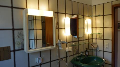 比斯平根Ferienhaus Schils Zur alten Heidegärtnerei的浴室设有水槽、镜子和灯