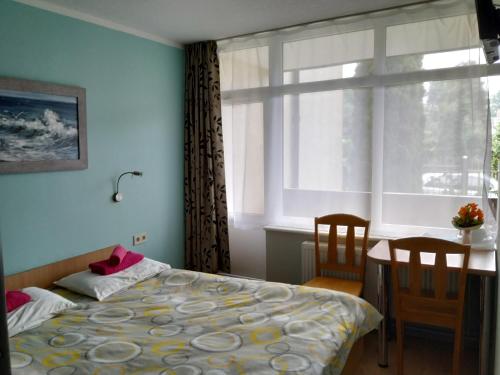 尤尔马拉Concordia的一间卧室配有一张床、一张桌子和一个窗户。