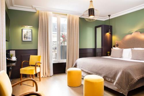 巴黎Hotel Monsieur & Spa的酒店客房带一张床、一张桌子和椅子