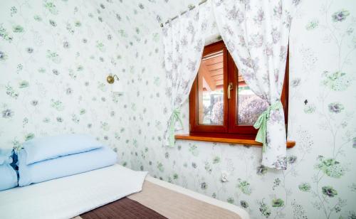 RaszówApartamenty Romanowka的卧室配有花卉图案的壁纸和窗户