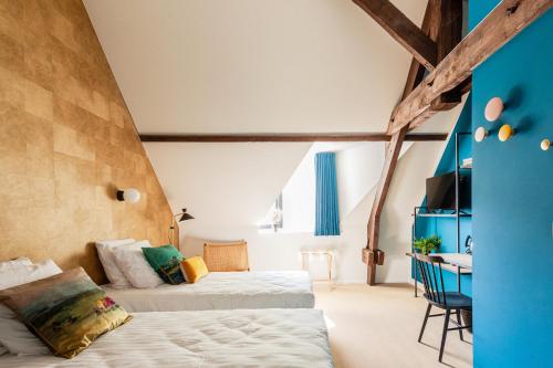 MaillenDomaine de Ronchinne - Maison du Jardinier的一间卧室配有两张床和一张书桌。