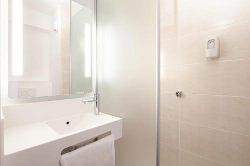 塞尔吉B&B HOTEL Cergy Saint Christophe的白色的浴室设有水槽和镜子