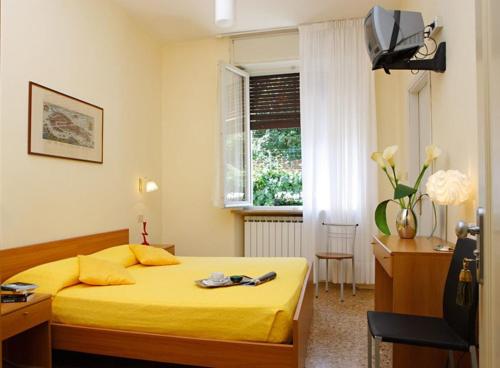 威尼斯Hotel Santa Lucia的一间卧室配有黄色的床和一张书桌