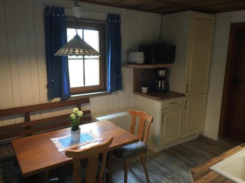Hörselberg-HainichCS-Ranchhaus的厨房配有木桌、椅子和窗户