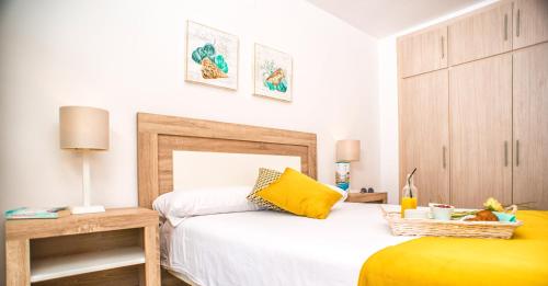 萨洛Ona Suites Salou的一间卧室配有一张黄色枕头的床