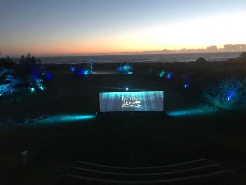 戈尔德比奇Pacific Reef Hotel & Light Show的享有带蓝色灯光的建筑的夜景