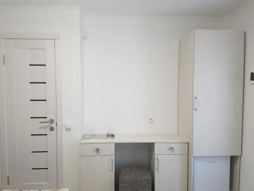 切尔诺夫策Apartments like hotel的白色的客房配有书桌和橱柜。