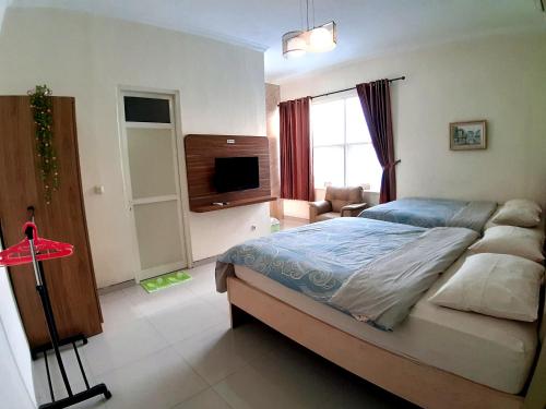 泗水留芳頌生活酒店的一间卧室配有一张床和一台电视