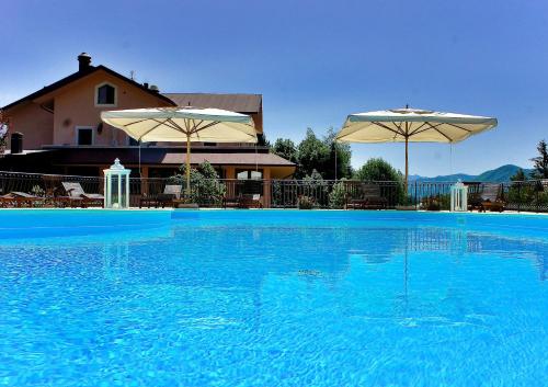 佩斯卡塞罗利布加内夫酒店的一个带两把遮阳伞的大型蓝色游泳池