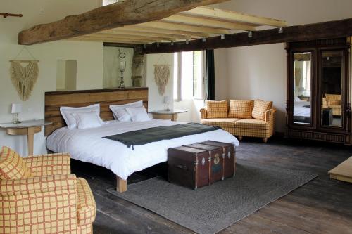 RanconGite La Grange de Jeanne的一间卧室配有一张大床和两把椅子
