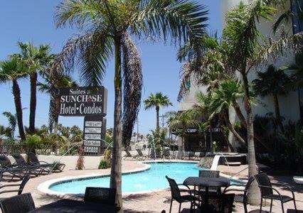南帕诸岛Sunchase Inn & Suites的度假村内带椅子和标志的游泳池