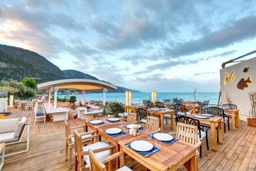 厄吕代尼兹Jade Residence的一间设有木桌和椅子的餐厅,享有海景