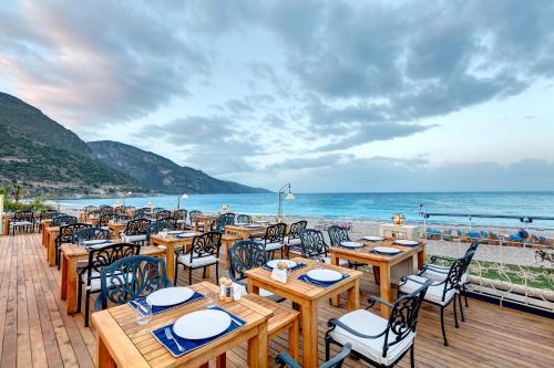 厄吕代尼兹Jade Residence的海滩上带桌椅的餐厅