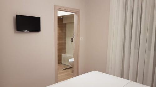 帕尔加Vito's Parga View Apartments的一间带卫生间的浴室和墙上的电视